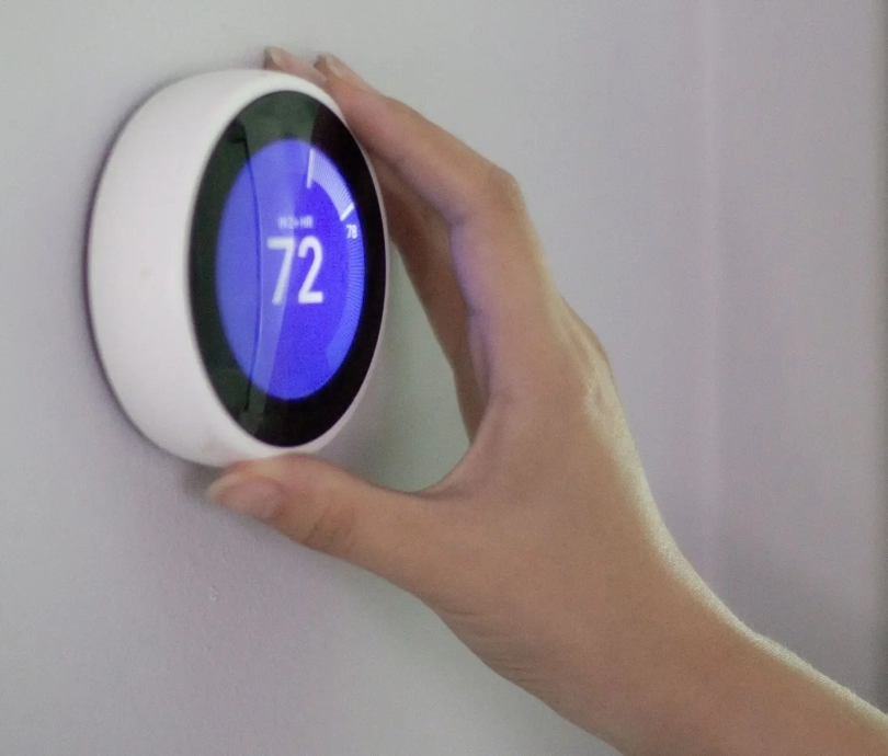 smart-thermostat-hand-99a75c6a997645f992447ff9e1928236
